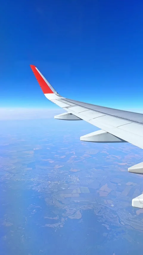 The plane flies over the city, preparing to land on the runway, window view Stock Footage 305600524