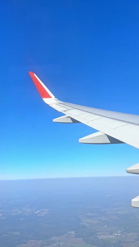 The plane flies over the city, preparing to land on the runway, window view Stock Footage 305600689