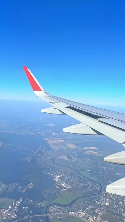The plane flies over the city, preparing to land on the runway, window view Stock Footage 305600768