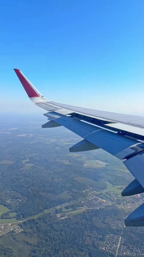 The plane flies over the city, preparing to land on the runway, window view Stock Footage 305601426