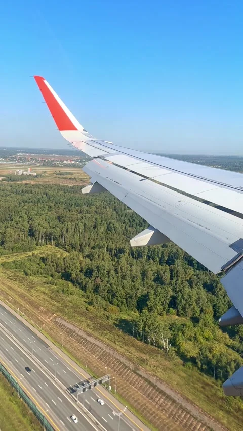 The plane flies over the city, preparing to land on the runway Stock Footage 305602677