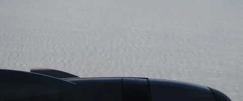 The plane flies over flat white clouds looking like snow. View through window Stock Footage 127135726