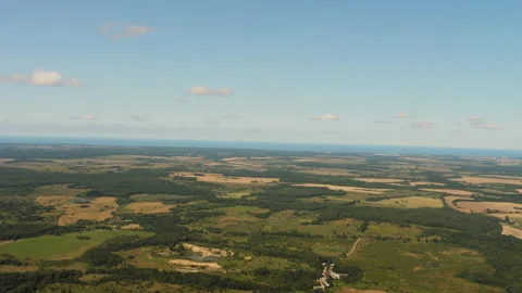 The plane flies over forests, fields, sea Stock Footage 158452004
