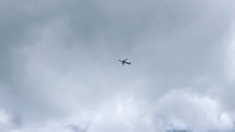 Plane flies over head in front of clouds, 4K Stock Footage 111329376