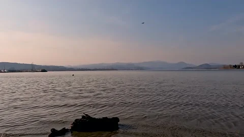 Plane flies over lake at sunset Stock Footage 200829385