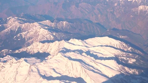 The plane flies over the snowy mountain peaks of the Alps, Leh, India. 動画素材 145963645