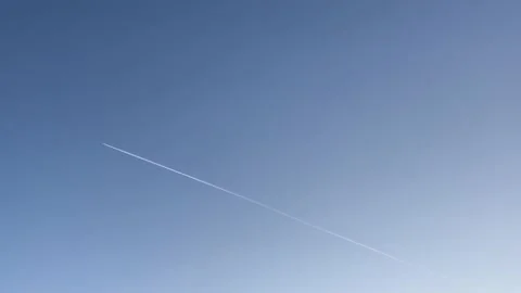 The plane flies in the sky. A trail from the plane in the sky. 動画素材 224709934