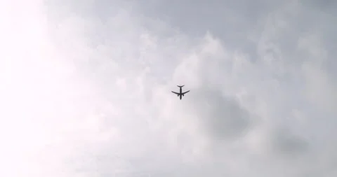 Plane Flies Through A Cloudy Sky And Over The City. Slow Motion. Stock Footage 252663672
