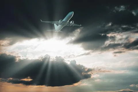 Plane flies through the dark clouds Stock Photos