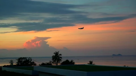 Plane flies through the dark orange sunset sky and lands at the airport. travel Stock Footage 230029489