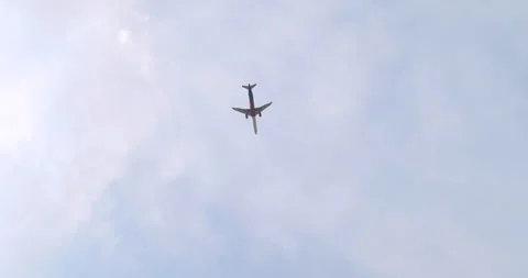 Plane flies through a sky full of thick clouds and over the city apartments Stock Footage 252663922