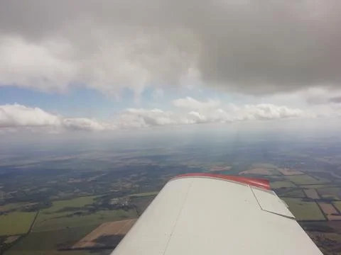 The plane flies under the clouds, the view from the cockpit. Stock Photos