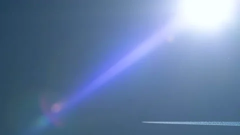 Plane flies under sun with real flare - 01 Stock Footage 132043052