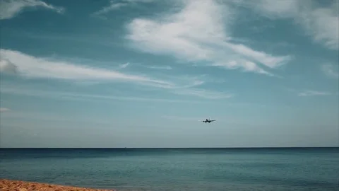 Plane flies very low over the beach. tourists watching airplane landing. Stock Footage 71272889