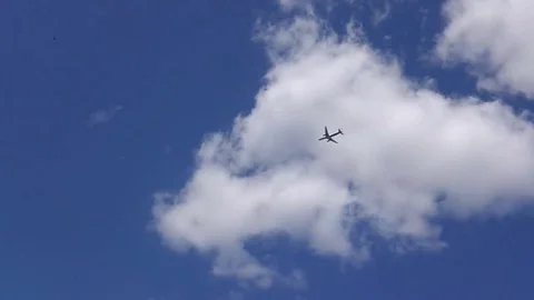 The plane flies in white clouds and a blue sky Stock Footage 78435979