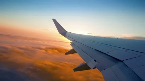 Plane flight above the clouds, sun glimpse over wing Stock Footage 71468012