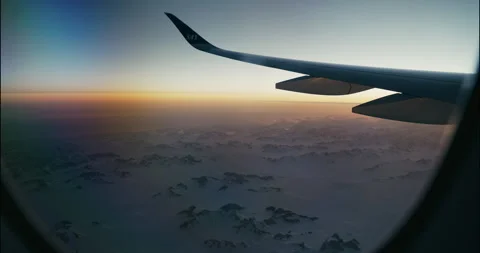 Plane Flight outside the window Greenland Mountains Ice See Snow Sunrise 4K Stock Footage 309878665