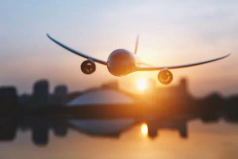 Plane in flight at sunset sky background. Stock Photos