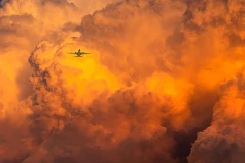 Plane fly over dramatic orange sky and clouds abstract background. Top view o Foto stock