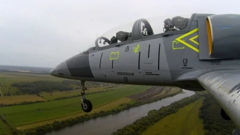 Plane fly over the river with open, released landing gears against overcast sky. Stock Footage 118677074