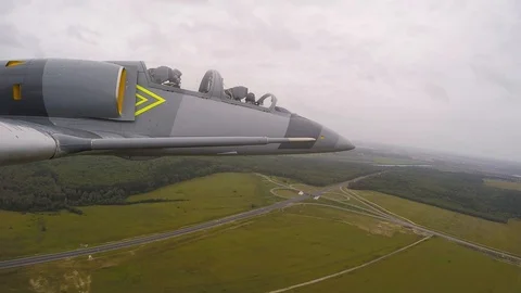 Plane fly over a road in field and rolls to the left. A fighter against dark sky Stock Footage 118676494