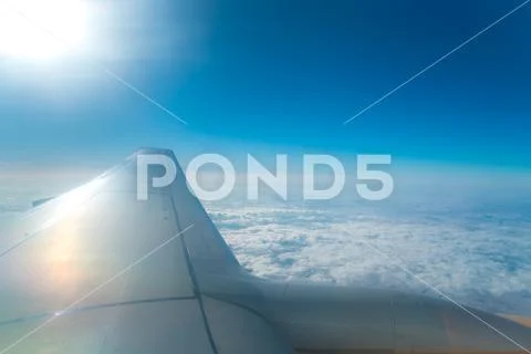 The plane fly in the sky on the background of the bright sun Stock Photos