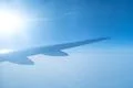 The plane fly in the sky on the background of the bright sun Photo