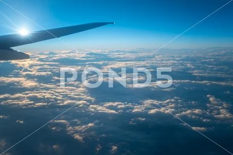 The plane fly in the sky with cloud on the background of bright sun Stock Photos