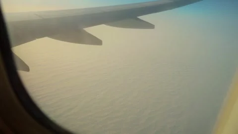 Plane flying above dense clouds at sunset, view from window porthole. Jet Stock Footage 329066655