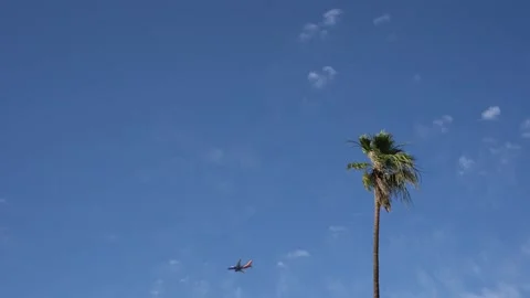 Plane Flying Across the Sky Coming In For Landing - Palm Springs, CA Stock Footage 221661076