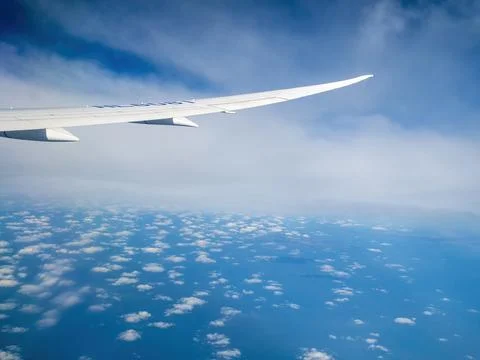 Plane flying between cloud layers viewed from passenger cabin window Stock Photos