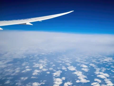 Plane flying between cloud layers viewed from passenger cabin window Stock Photos