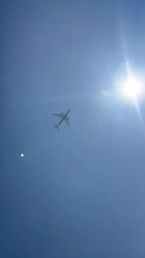 Plane flying in blue sky with sun in the background Stock Footage 337120292