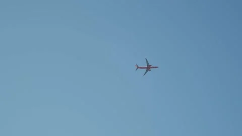 Plane flying in bright blue sky Stock Footage 167685232