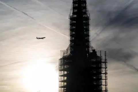 Plane flying into a building under construction. 写真素材