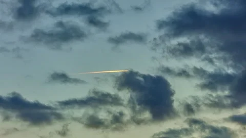 Plane flying with contrail in dramatic sunset view with colorful streak across Stock Footage 313731774