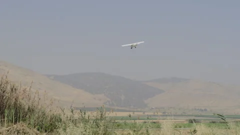 Plane flying in the distance over fields Stock Footage 275381863
