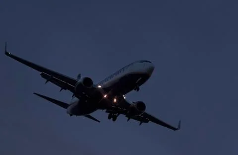 Plane flying at dusk Stock Photos