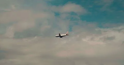 Plane flying going along the clouds gaining altitude. Stock Photos
