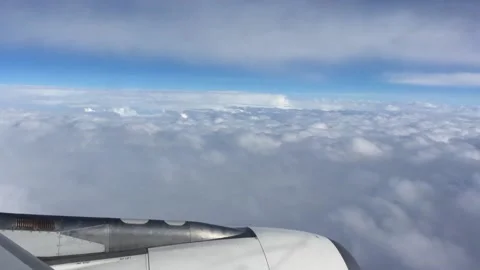 A plane flying high in the sky above clounds Stock Footage 162247735