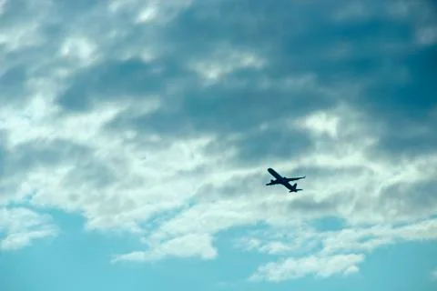 Plane flying high in sky. View to air liner flying in blue sky Stock Photos
