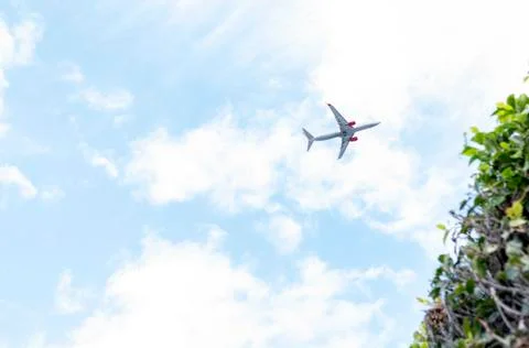 Plane flying at low altitude in a cloud sky and cleared Stock Photos