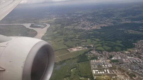 Plane flying over field and small city 库存影片 242452448
