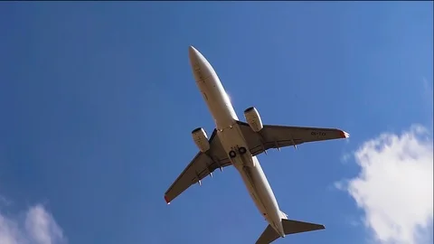 Plane flying over head on blue sky. Airplane takeoff into the sky. Stock Footage 96216995