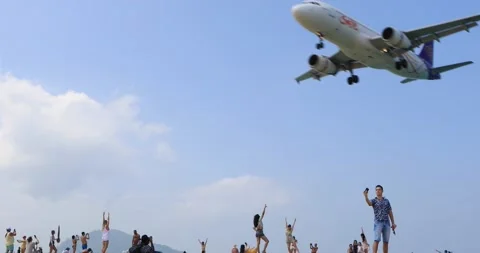 Plane is flying over the head of traveller at Nai-Yang Beach Phuket Stock Footage 149455024