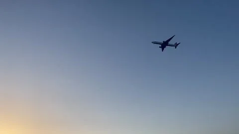 Plane flying over Mediterranean Sea by sunrise Stock Footage 337177553