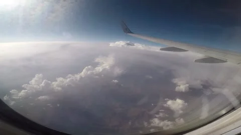 A plane flying over the mountains. High mountains under the clouds. View from Stock Footage 145193809