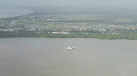 Plane flying over river and city in Guyana Stock Footage 513442