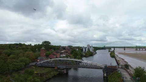 Plane flying over Runcorn old quay swing bridge on the ship canal Mersey Stock Footage 346223087