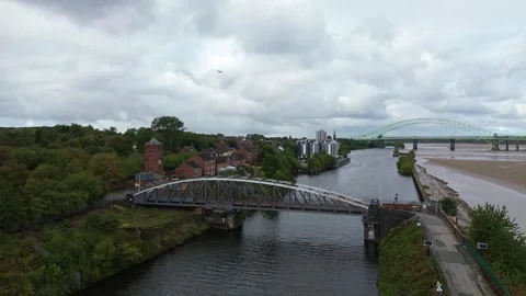 Plane flying over ship canal and Runcorn old quay swing bridge Mersey waterfront Stock Footage 346223031